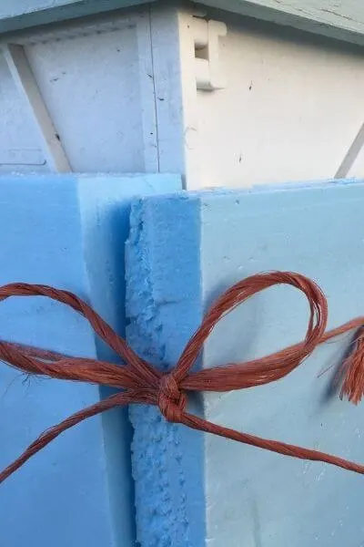 Bee boxes wrapped in insulation with orange twine