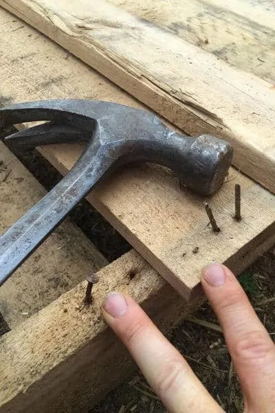 pulling nails out of a pallet to make it useful for building