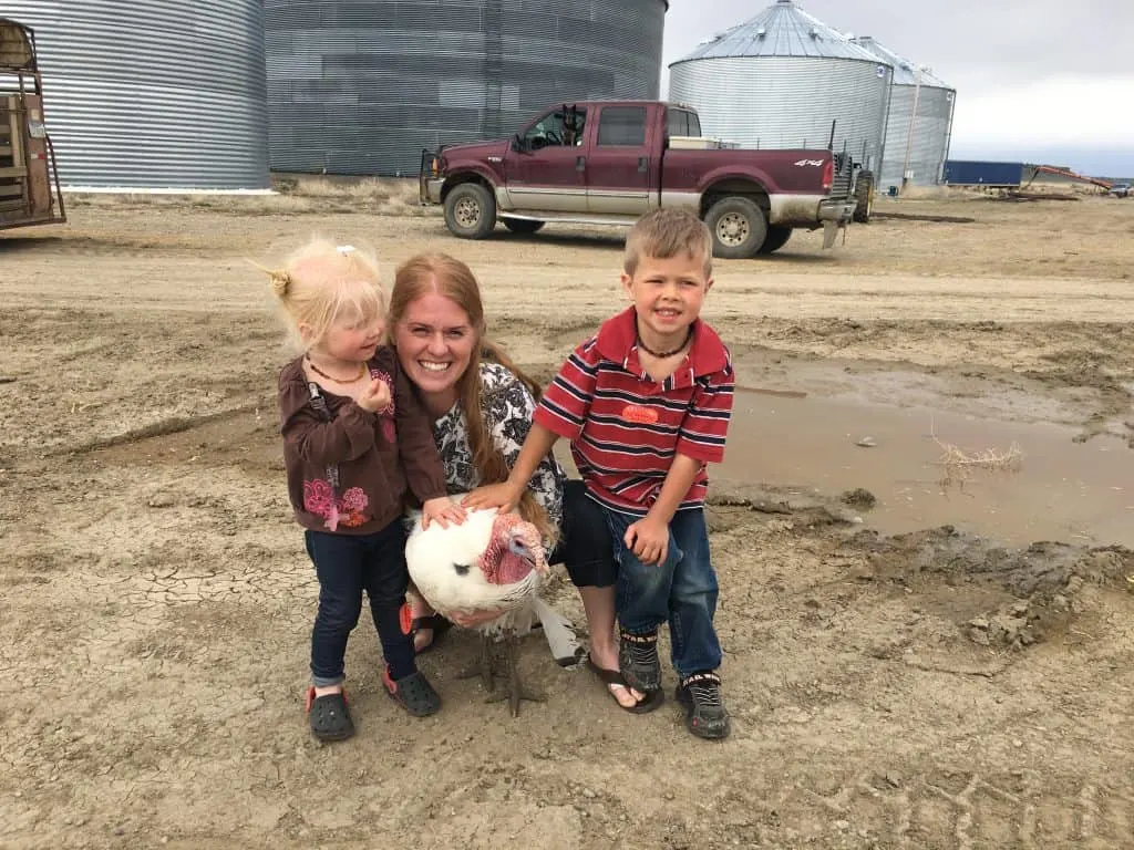 Turkey being held by mom and kids. Turkeys can be friendly pets too!