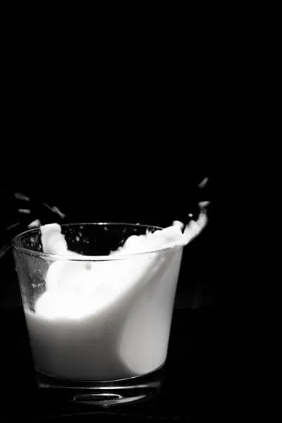 Cup of milk splashing asking the question: is raw milk safe?